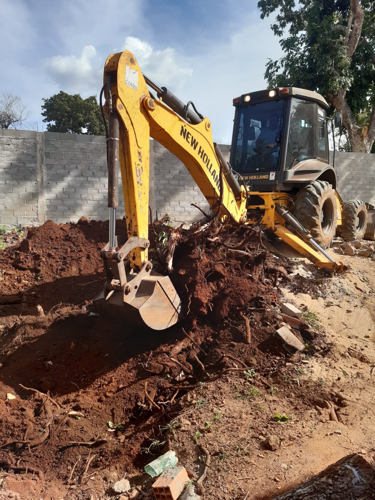 Retroescavadeira executando escavação em terreno